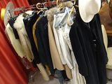 beaucoup de vêtements suspendus à une étagère dans une pièce
