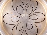 a close up of a metal plate with a flower design on it