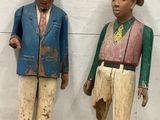 two wooden figurines of men standing next to each other