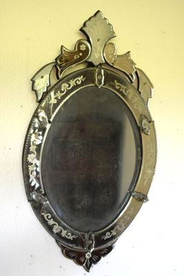 a mirror hanging on the wall with a bird on it