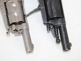 two revolvers that are sitting side by side on a table