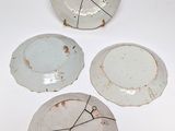 three white plates with black lines on them on a white surface