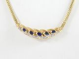 a yellow gold necklace with blue sapphires and diamonds