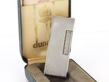 a silver lighter sitting in a case on a white surface