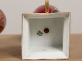 a red and gold ornament in a square box