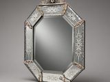 an ornately decorated mirror with a silver frame on a gray background