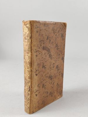 an old book sitting on top of a white surface
