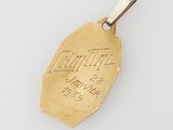a gold plated pendant with the name of a man