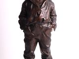 bronze statue of a boy with a hat and a baseball cap
