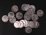 a pile of silver coins on a black surface