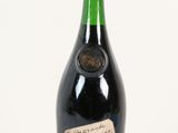 une bouteille de vin avec une étiquette, posée sur une surface blanche