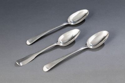 trois cuillères et deux cuillères posées sur une table avec un fond gris