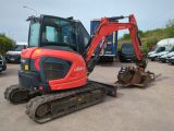 an image of a small excavator parked in a parking lot
