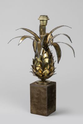 an image of a brass vase with a pineapple on a wooden base