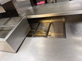stainless steel counter top with open drawers in a commercial kitchen