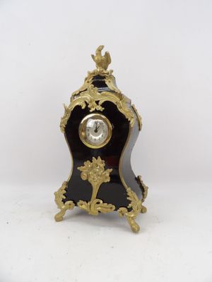 une horloge noire et or sur fond blanc
