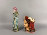 two figurines of a woman and a man with a hat