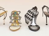 three pairs of women ' s high heeled shoes are lined up on a white surface