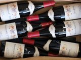 six bottles of wine in a cardboard box on the table