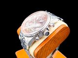 a watch sitting on a wooden stand on a black background