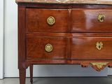 a wooden chest of drawers with a marble top