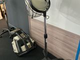 a hair dryer sitting on a stand next to a fan