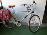 un vélo blanc avec un sac rouge à l'arrière