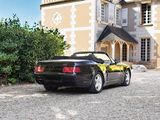 a black sports car parked in front of a large house