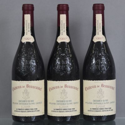 three bottles of wine sit on a glass shelf in front of a gray wall