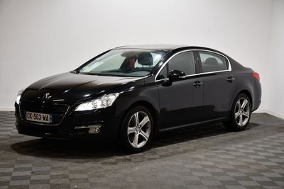 Une voiture noire est garée sur un sol à damier dans une pièce.