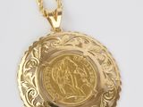 a close up of a gold coin on a gold chain
