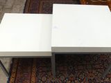 deux tables basses blanches posées sur une moquette recouverte d'un tapis