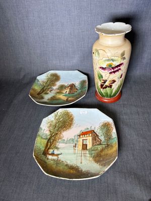 trois assiettes et un vase posés sur une table