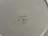 une assiette blanche avec une inscription dessus, posée sur une table