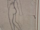 drawing of a nude woman in a gold frame on a wall
