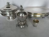 three silver plated dishes and a silver cup on a table