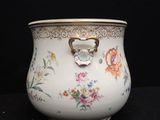 a white vase with a heart shaped handle on it