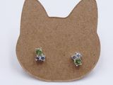 a pair of green and blue crystal stud earrings on a cardboard board