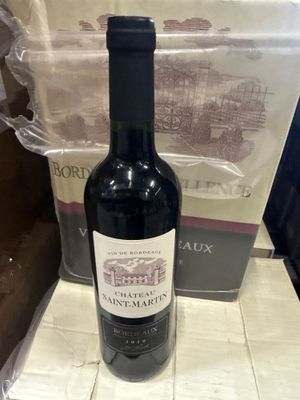 une bouteille de vin posée sur un comptoir à côté d'un colis