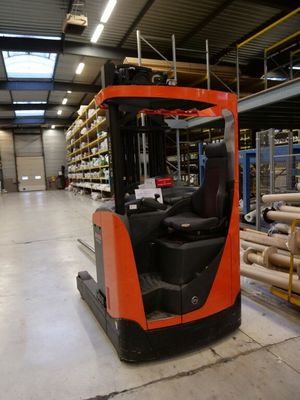 a forklift in a warehouse with a lot of shelves