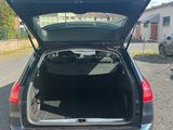 l'arrière d'une voiture dont le coffre est ouvert, sur un parking