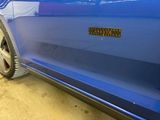 a close up of a blue car with a sticker on it