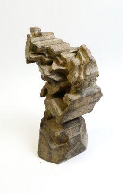 a stone sculpture that is sitting on a white surface