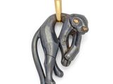 une image représentant un pendentif en forme de singe noir et doré sur fond blanc