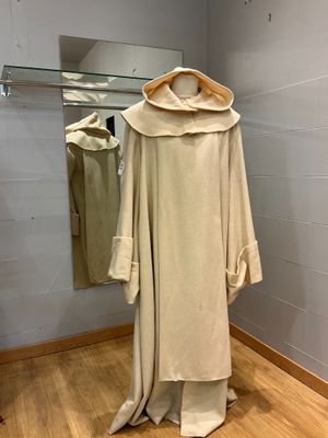 une robe blanche suspendue à un cintre dans une pièce