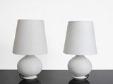 deux lampes blanches posées sur une table noire, avec un abat-jour blanc