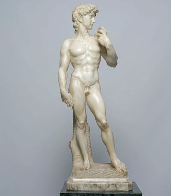 a white marble statue of a man standing on top of a table