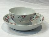 a bowl and saucer sitting on a white table