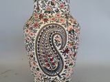 un vase orné d'un motif paisley, posé sur une table