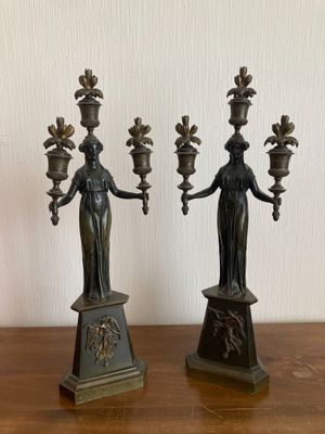 pair of antique bronze candlesticks of the person